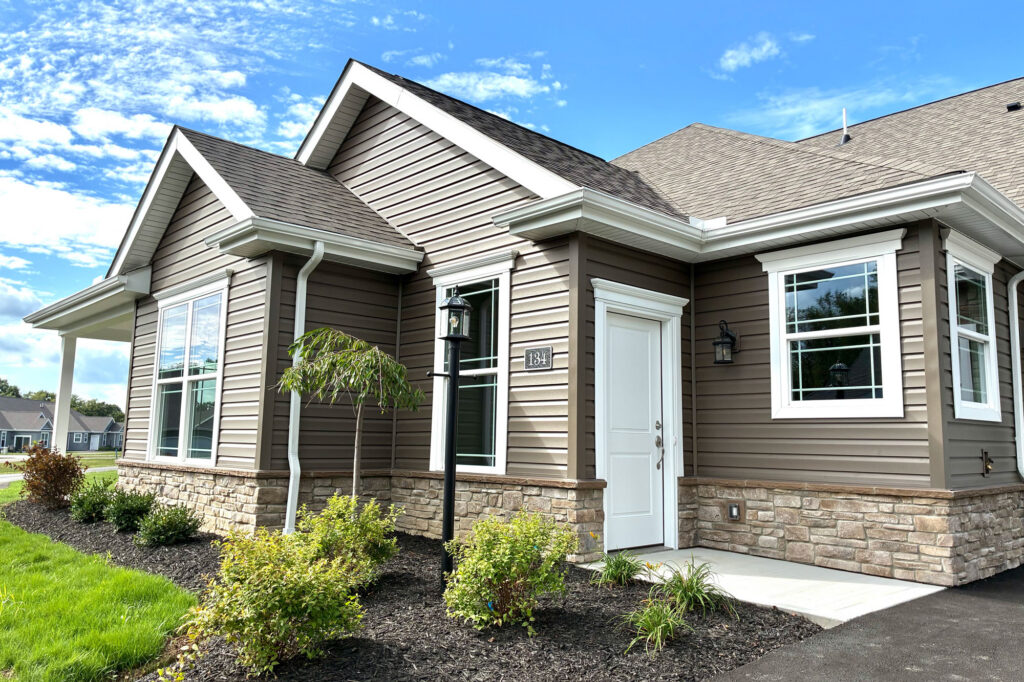 134independencedr105a | Pitell Homes A house featuring brown siding complemented by white trim showcasing a classic and inviting exterior design