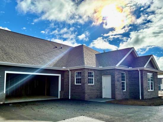146independencedr unit106c | Pitell Homes A sunny home with a garage showcasing a clear blue sky above